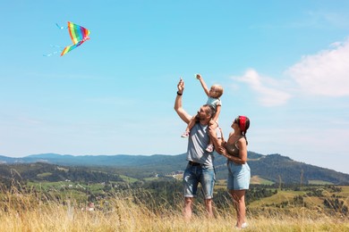 Photo of Happy family flying kite at field under blue sky