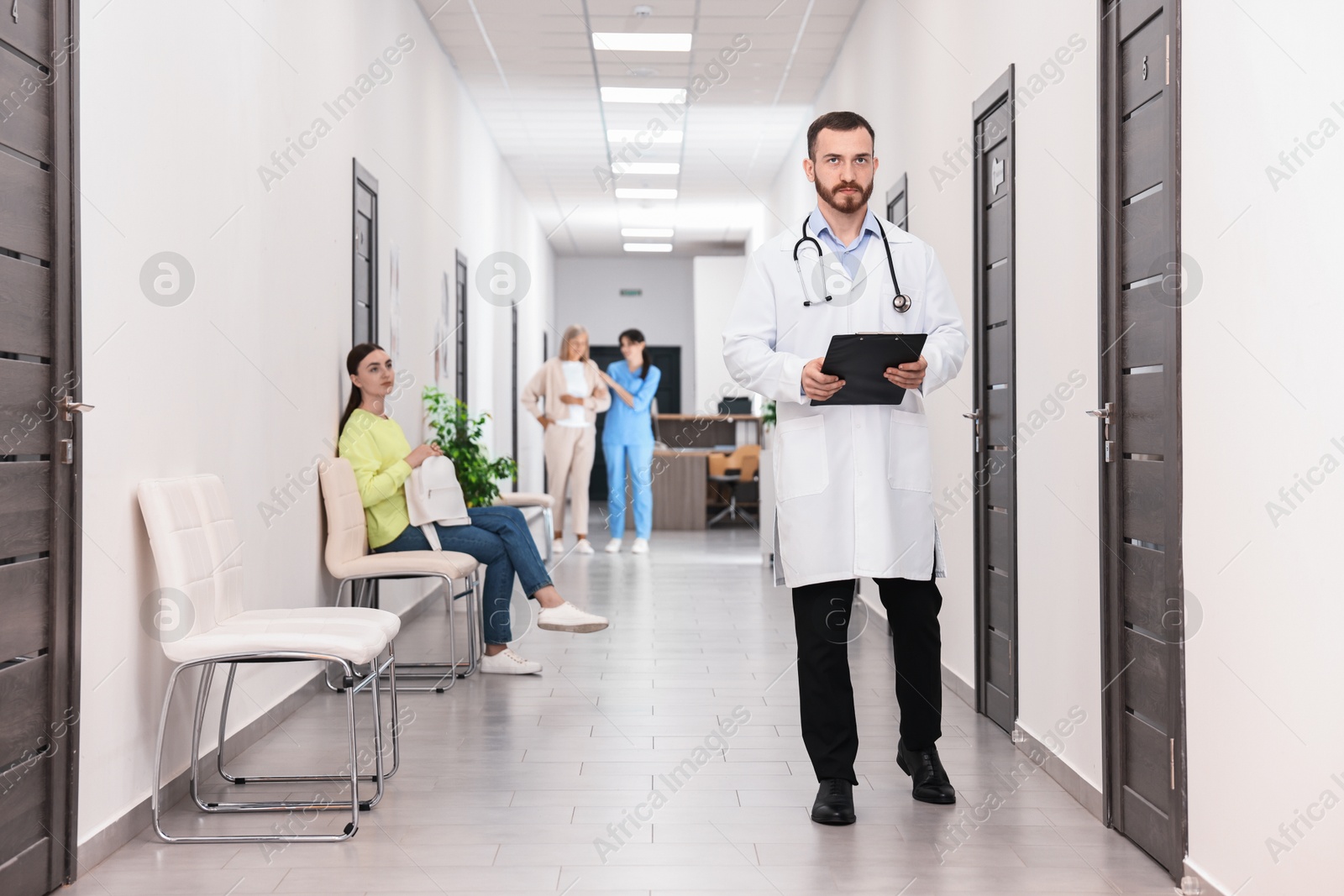 Photo of Patients waiting for appointment and doctors in hospital hallway, selective focus