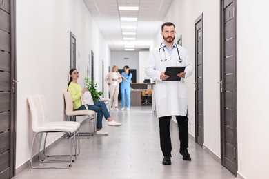 Patients waiting for appointment and doctors in hospital hallway, selective focus