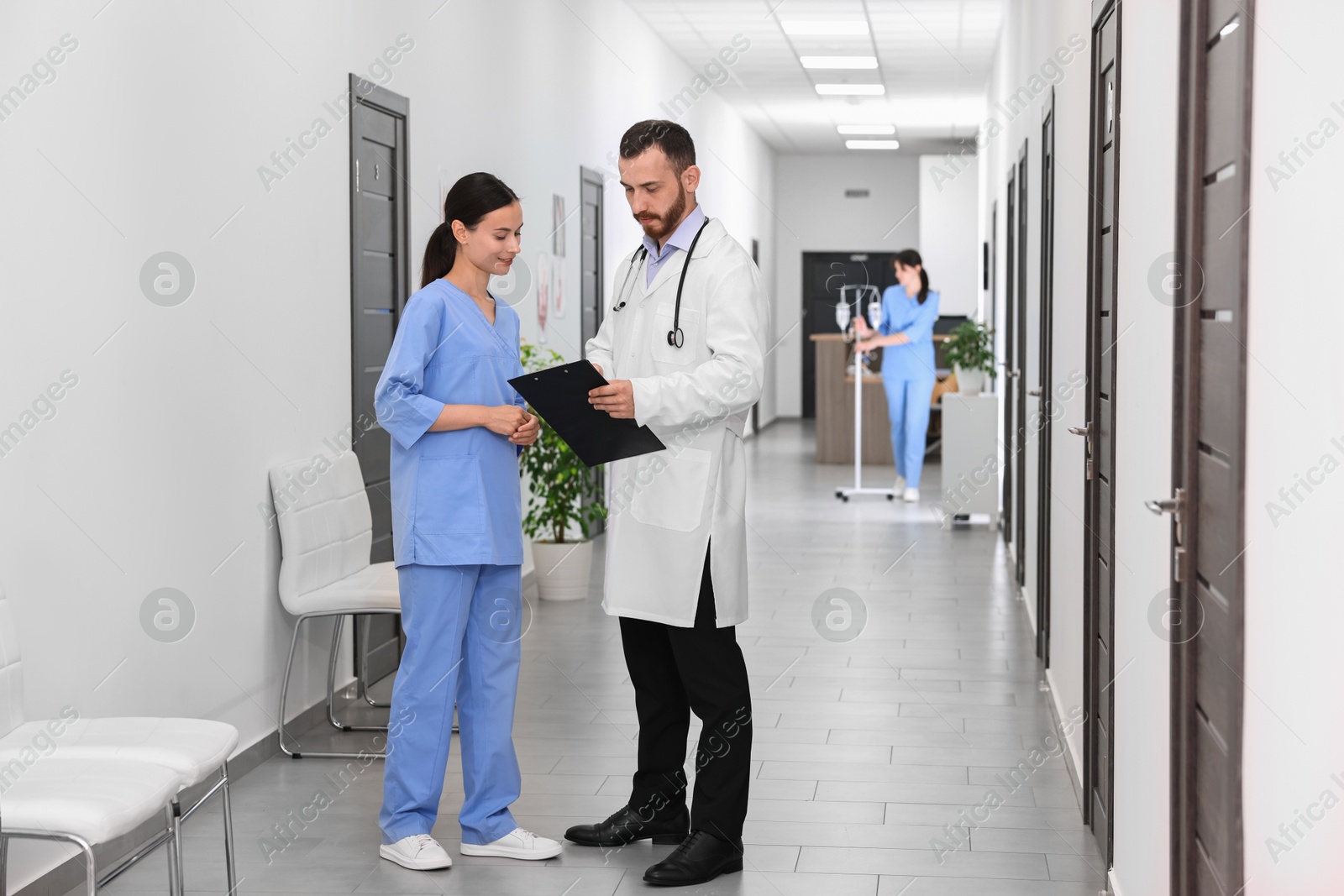 Photo of Doctor and nurse talking in hospital hallway