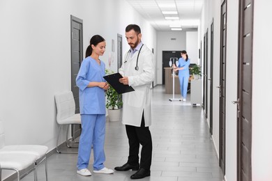 Doctor and nurse talking in hospital hallway