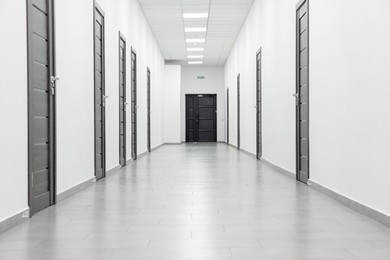 View of empty hospital corridor with wooden doors