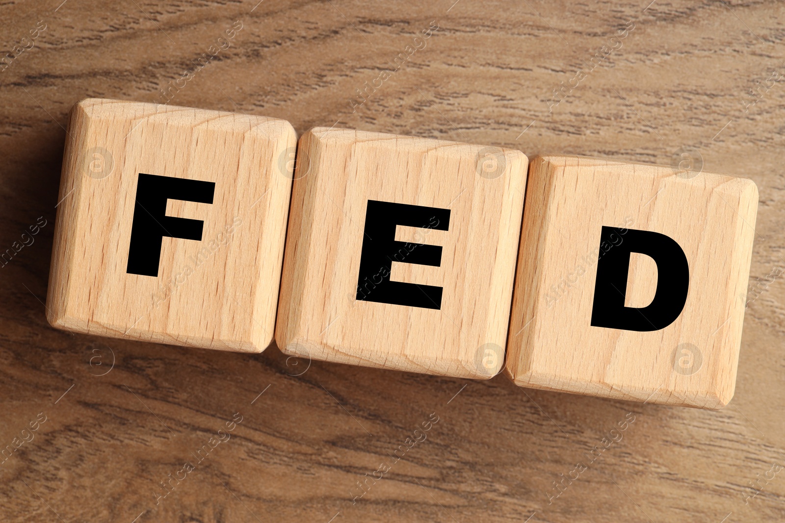 Photo of Cubes with letters Fed (Federal Reserve System) on wooden table, top view