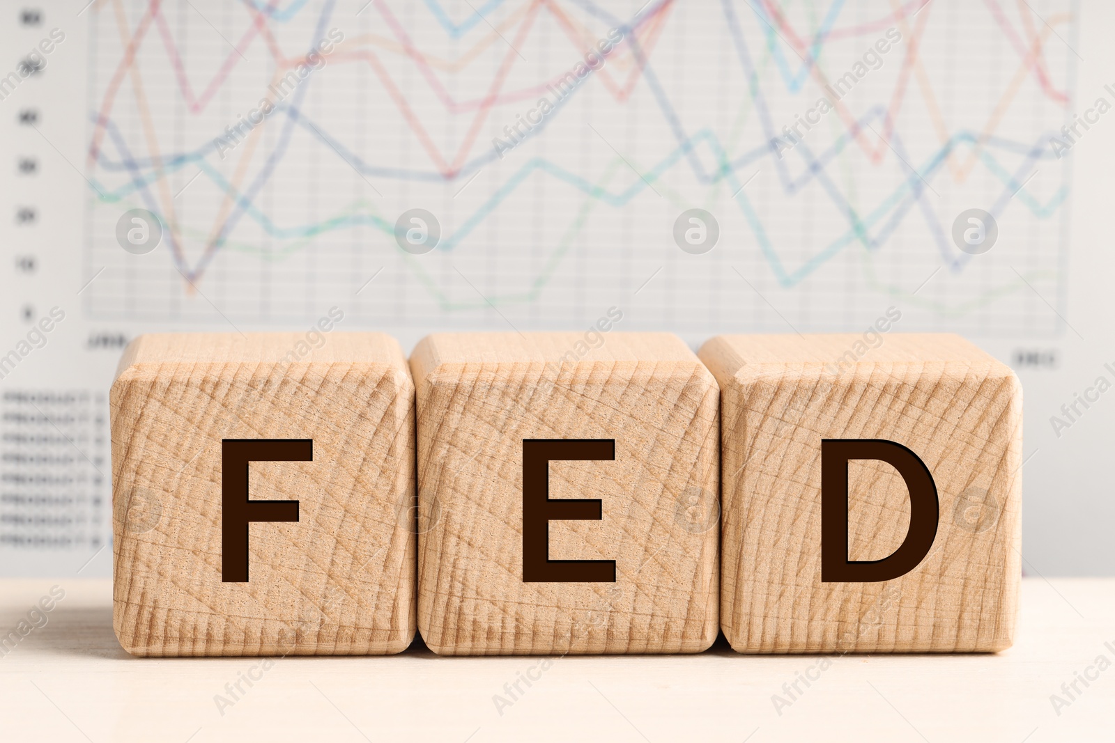 Photo of Cubes with letters Fed (Federal Reserve System) on wooden table, closeup