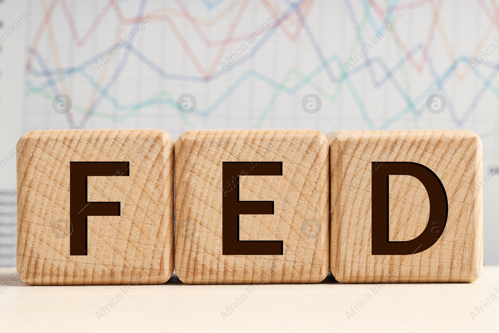 Photo of Cubes with letters Fed (Federal Reserve System) on wooden table, closeup