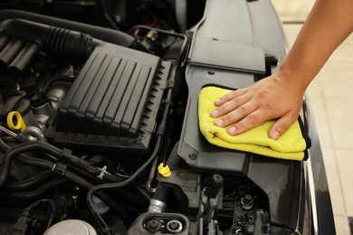 Photo of Man wiping auto engine with rag at car wash, closeup