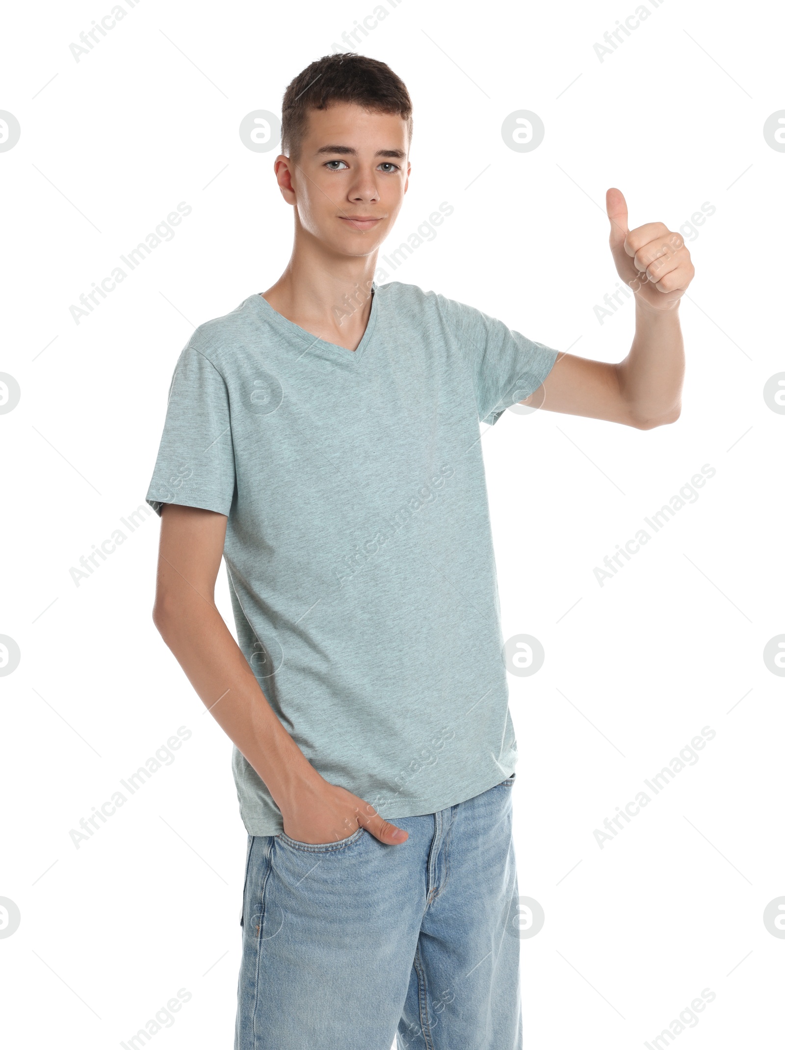 Photo of Teenage boy wearing light grey t-shirt and showing thumbs up on white background