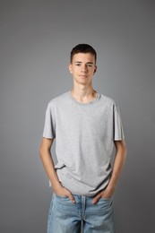 Photo of Teenage boy wearing t-shirt on grey background