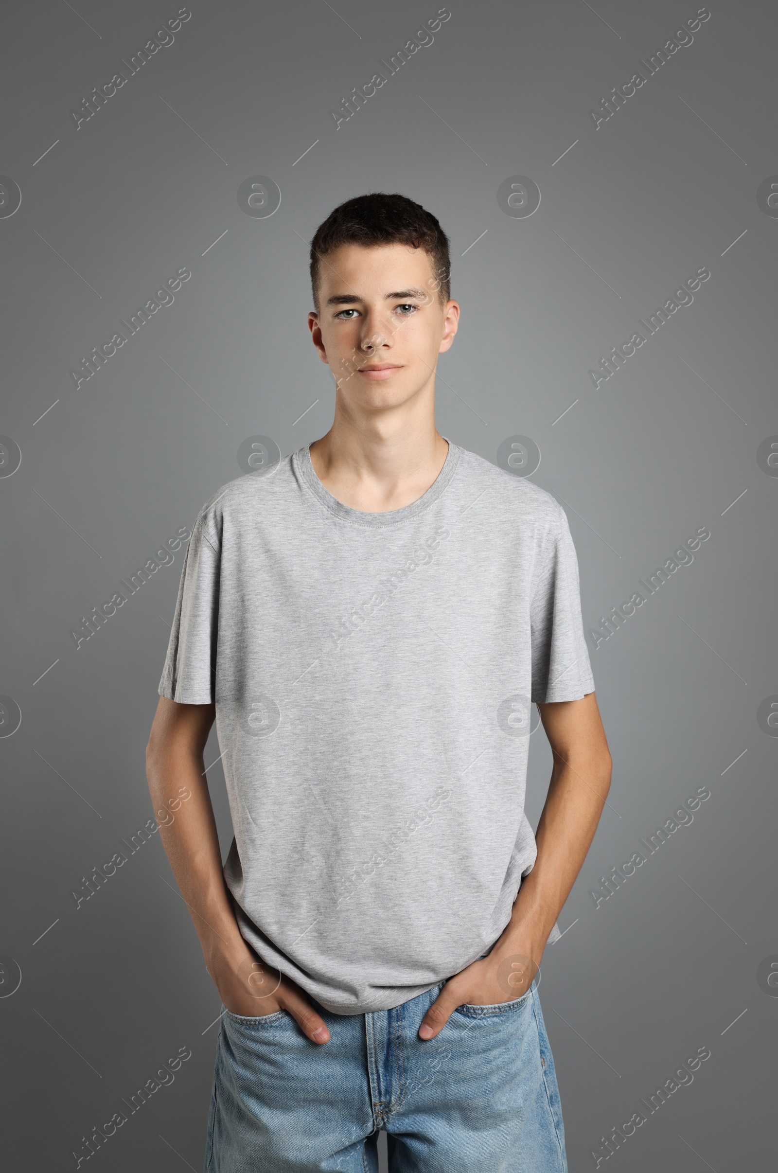 Photo of Teenage boy wearing t-shirt on grey background