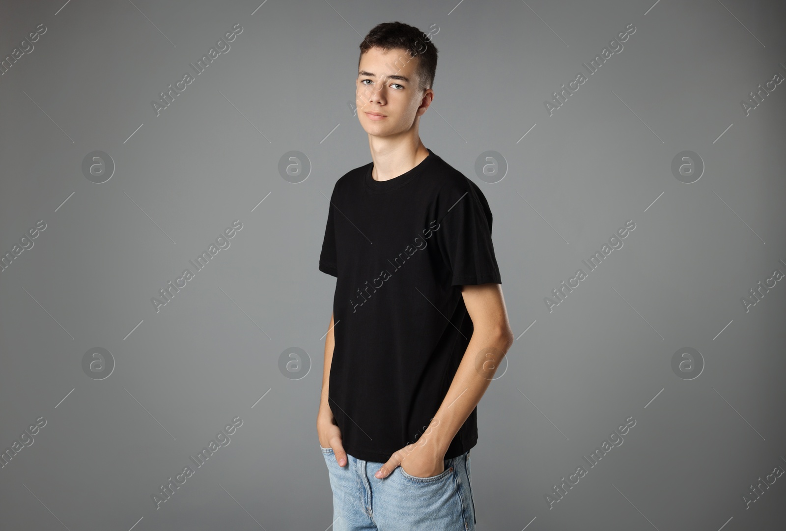 Photo of Teenage boy wearing black t-shirt on grey background