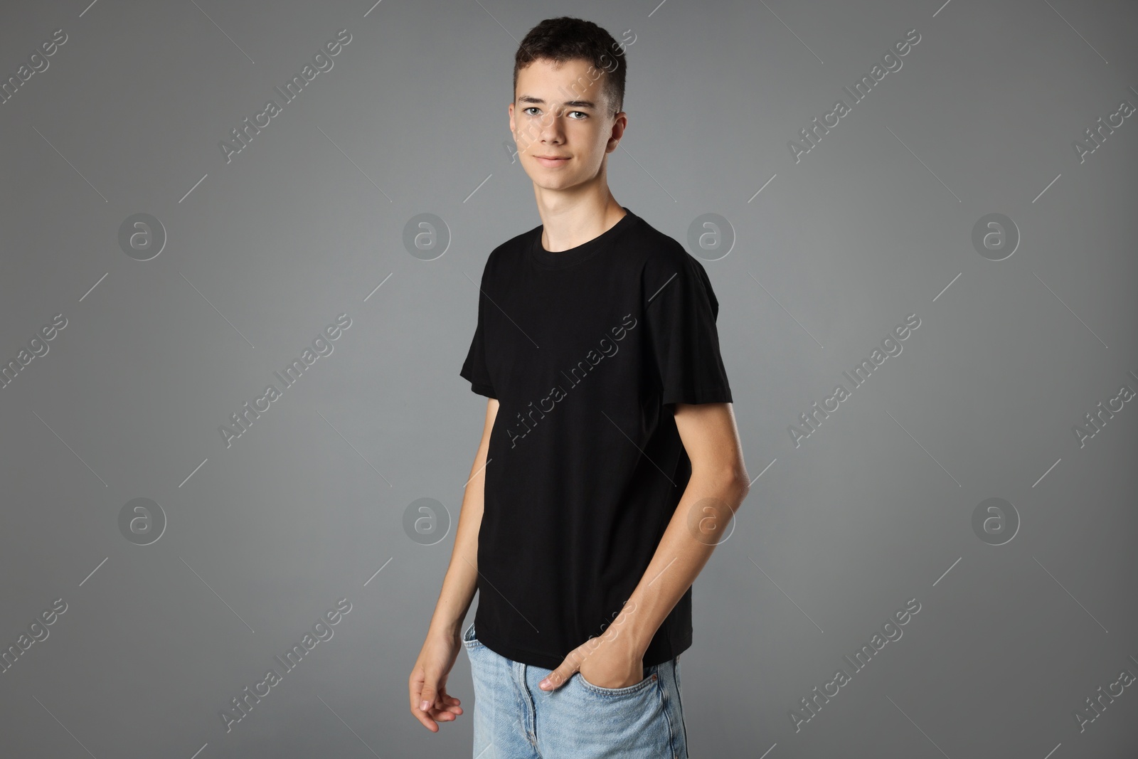 Photo of Teenage boy wearing black t-shirt on grey background