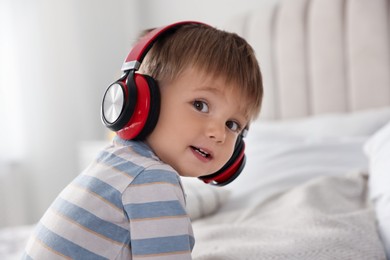 Cute little baby in headphones at home