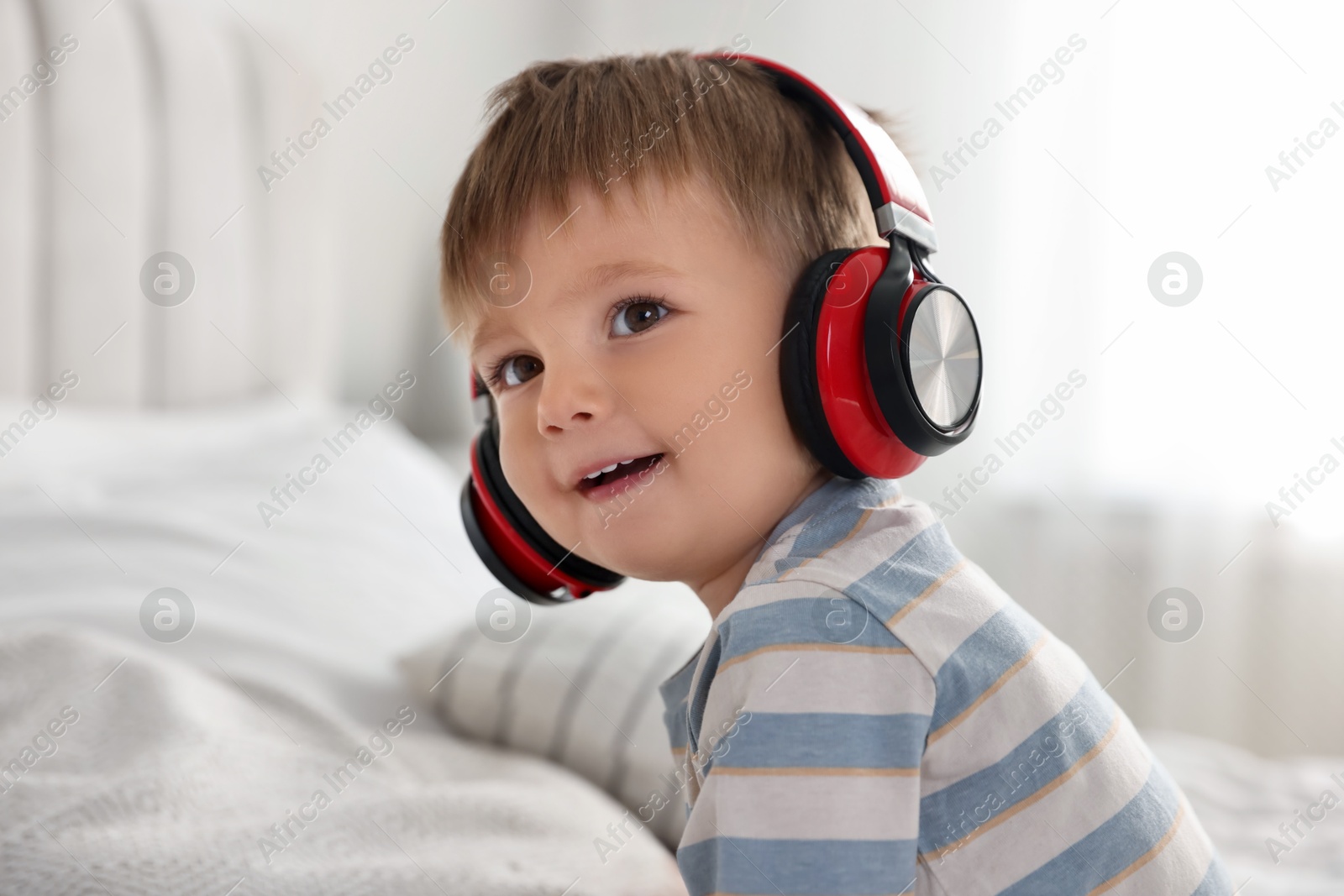 Photo of Cute little baby in headphones at home