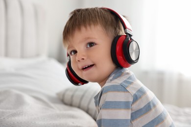 Cute little baby in headphones at home