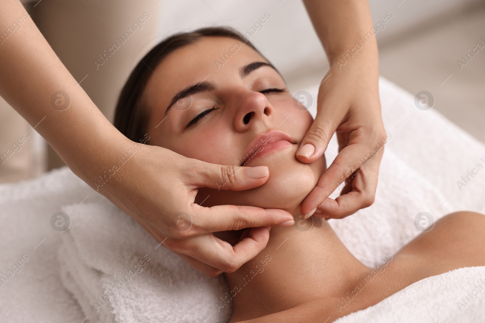 Photo of Attractive woman enjoying face massage, closeup. Beauty procedure