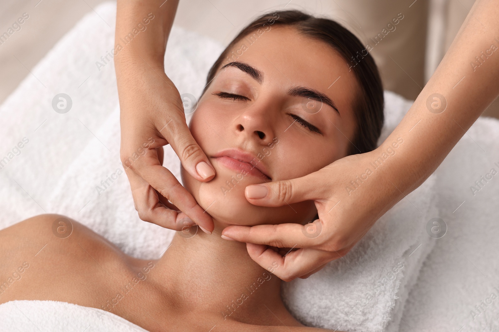 Photo of Attractive woman enjoying face massage, closeup. Beauty procedure