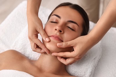 Photo of Attractive woman enjoying face massage, closeup. Beauty procedure