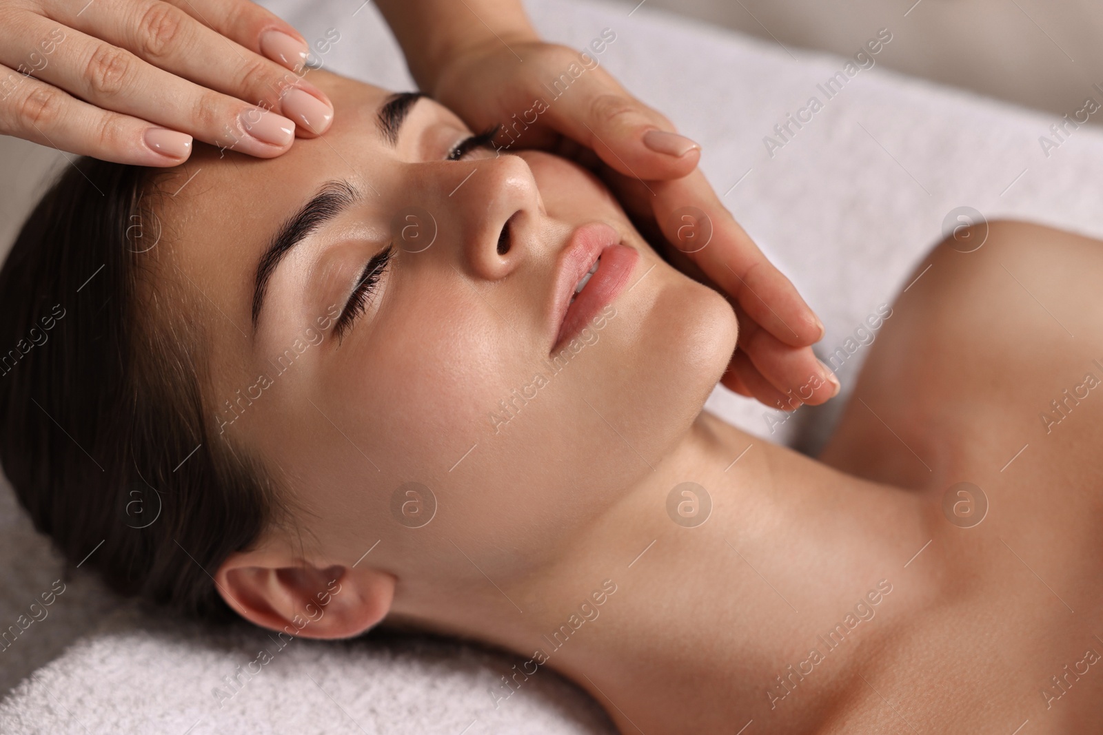 Photo of Attractive woman enjoying face massage, closeup. Beauty procedure