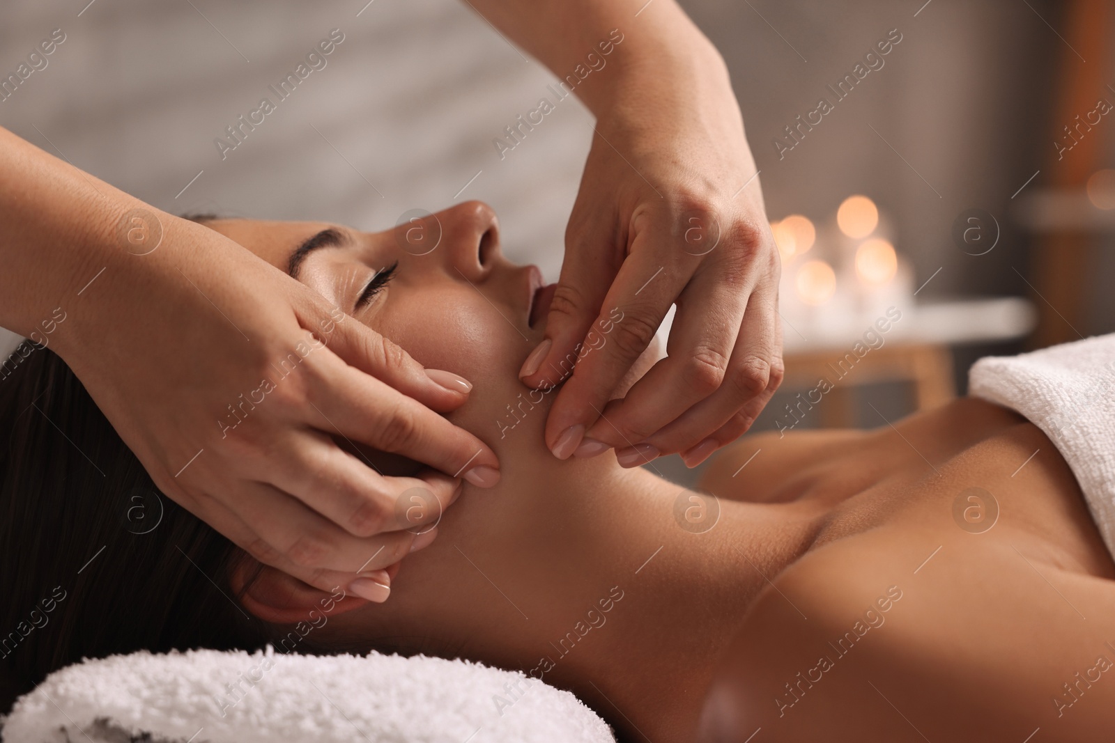 Photo of Attractive woman enjoying face massage, closeup. Beauty procedure