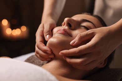 Photo of Attractive woman enjoying face massage, closeup. Beauty procedure