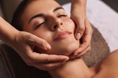 Attractive woman enjoying face massage, closeup. Beauty procedure