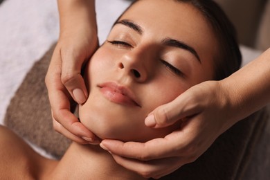 Photo of Attractive woman enjoying face massage, closeup. Beauty procedure