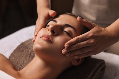 Photo of Attractive woman enjoying face massage, closeup. Beauty procedure