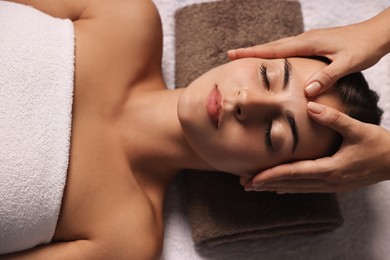 Photo of Attractive woman enjoying face massage, above view. Beauty procedure