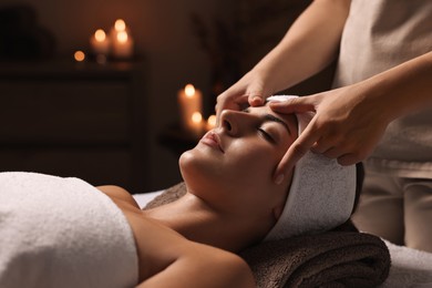 Photo of Attractive woman enjoying face massage in spa salon, closeup