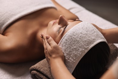 Photo of Attractive woman enjoying face massage, closeup. Beauty procedure