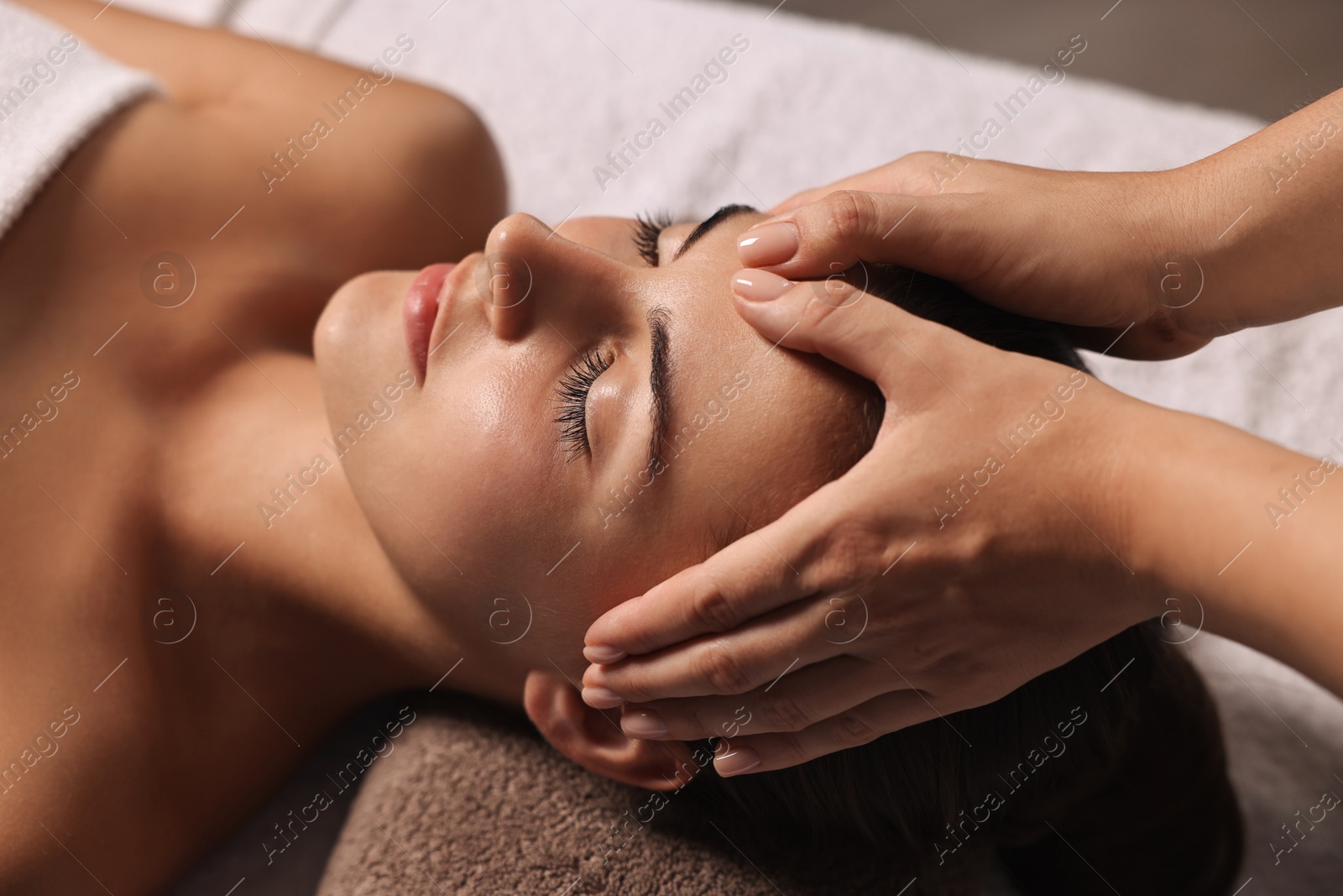 Photo of Attractive woman enjoying face massage, closeup. Beauty procedure