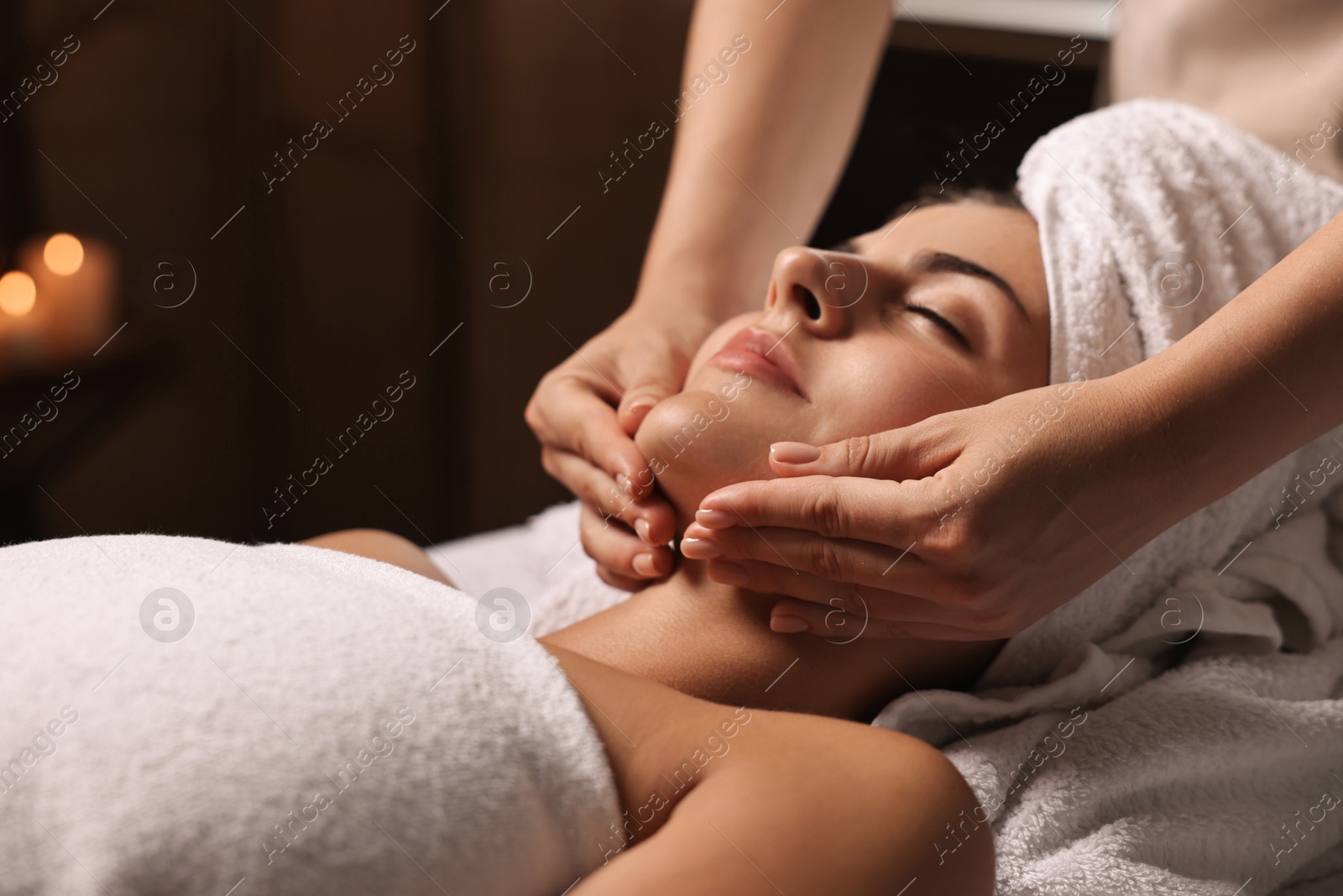 Photo of Attractive woman enjoying face massage, closeup. Beauty procedure