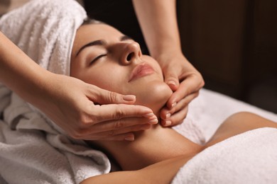 Photo of Attractive woman enjoying face massage, closeup. Beauty procedure