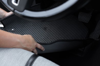 Photo of Man taking grey rubber car mat from auto, closeup