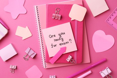 Photo of Paper note with question Are You Ready For Exam and stationery on pink background, flat lay