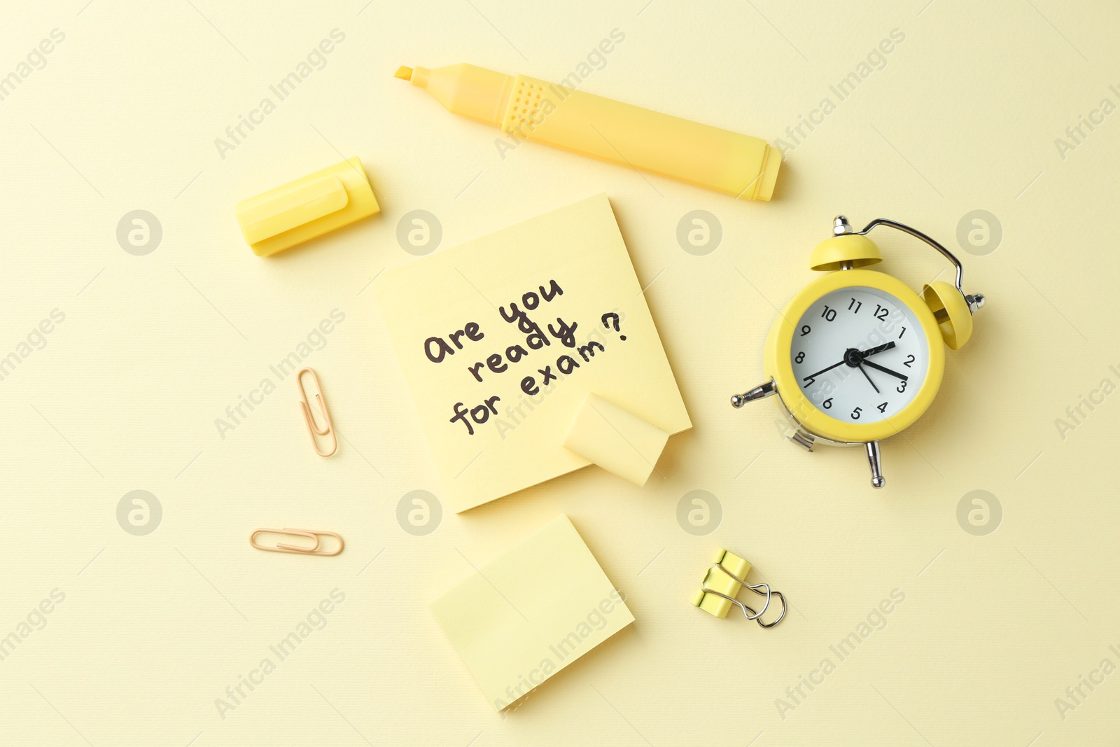 Photo of Paper note with question Are You Ready For Exam and stationery on pale yellow background, flat lay