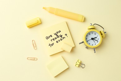 Photo of Paper note with question Are You Ready For Exam and stationery on pale yellow background, flat lay