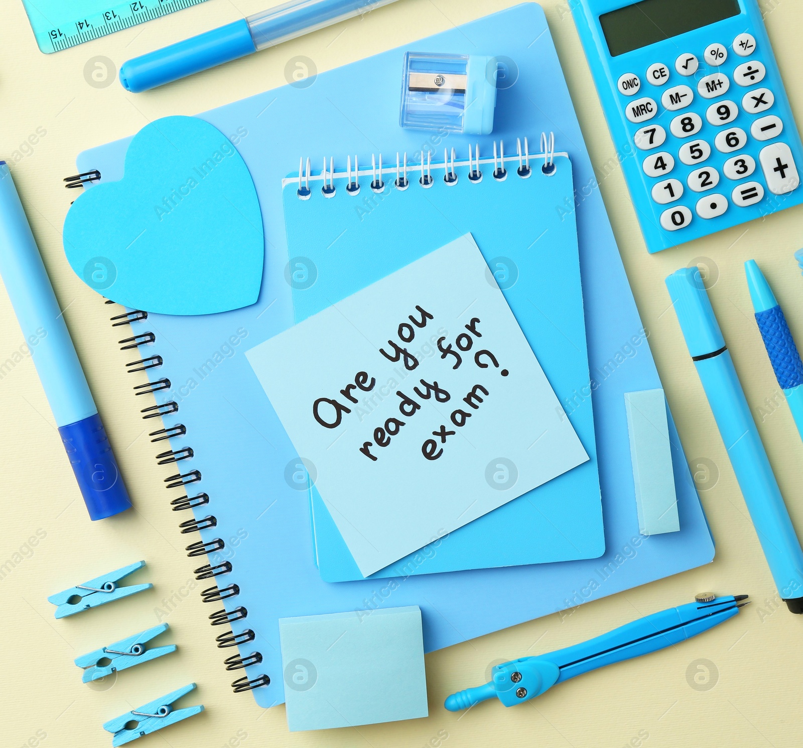 Photo of Paper note with question Are You Ready For Exam and stationery on pale yellow background, flat lay