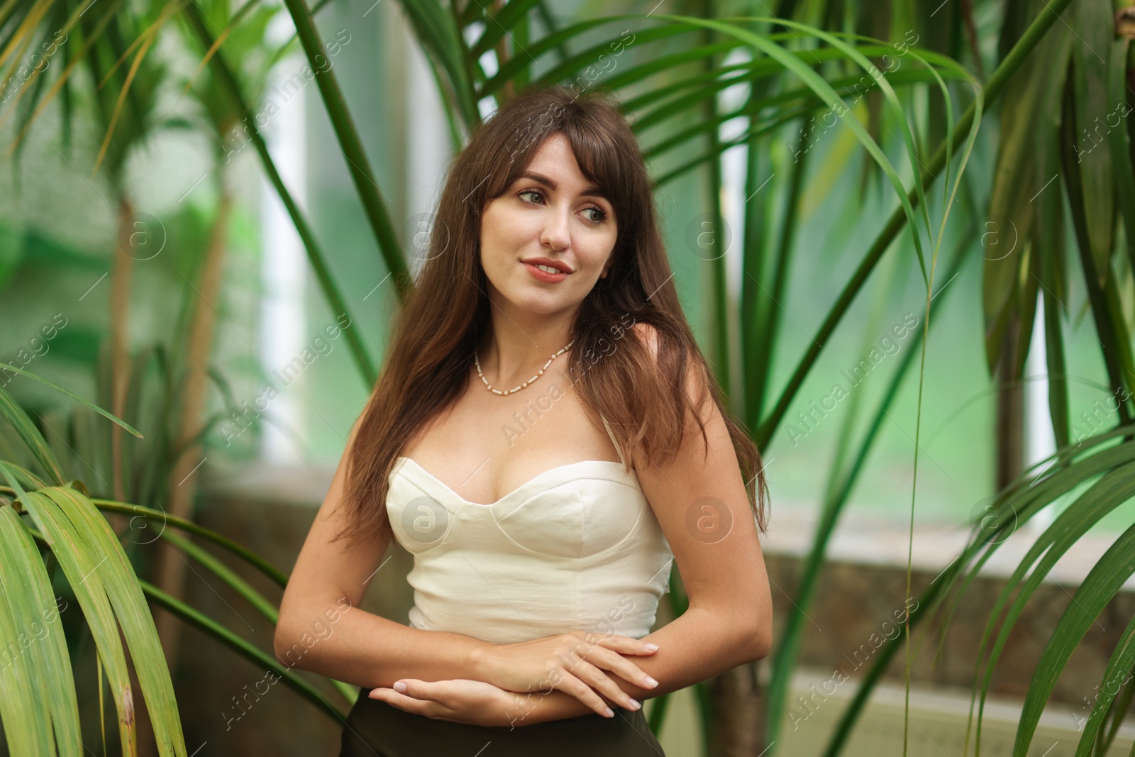 Photo of Beautiful woman near palm tree leaves outdoors