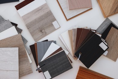 Photo of Different samples of wooden flooring on white table, top view