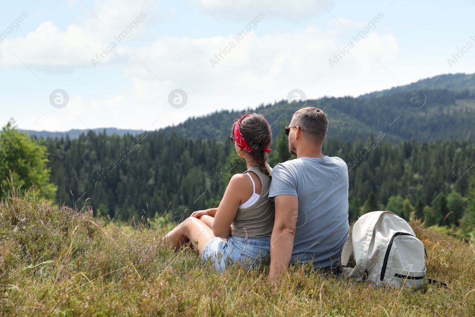 Photo of Couple with backpack enjoying picturesque landscape, back view. Active tourism