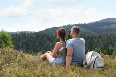 Couple with backpack enjoying picturesque landscape, back view. Active tourism