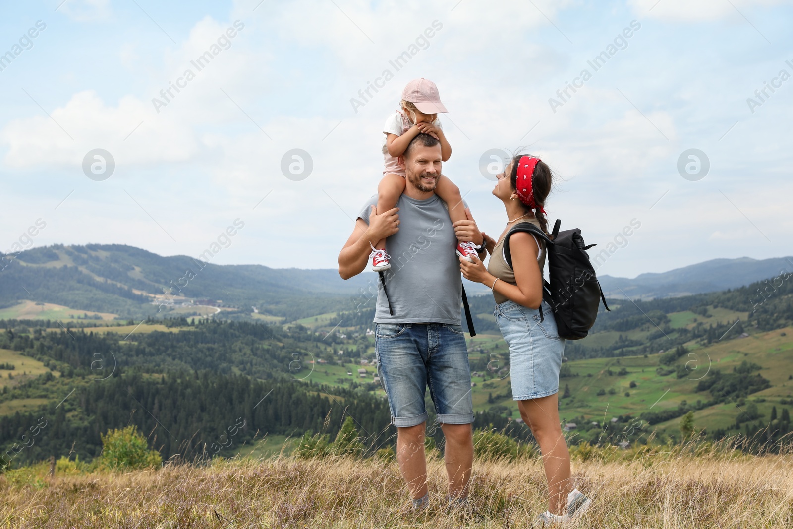 Photo of Happy family with backpacks travelling in mountains, space for text. Active tourism