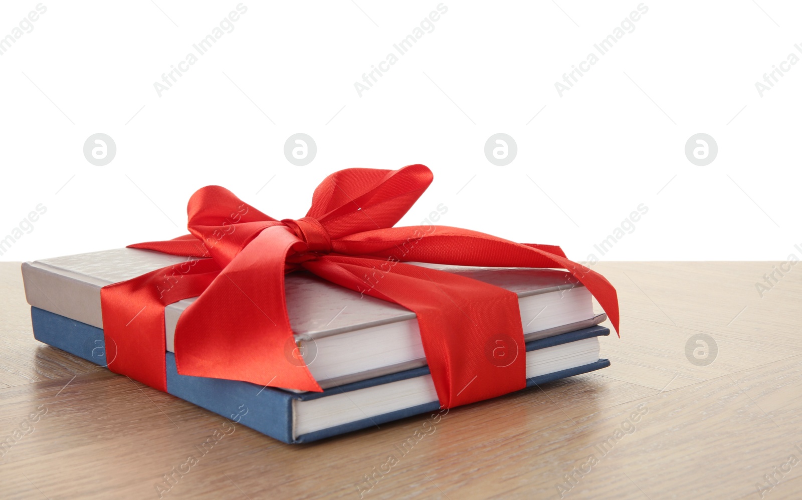 Photo of Books with ribbon as gift on wooden table against white background