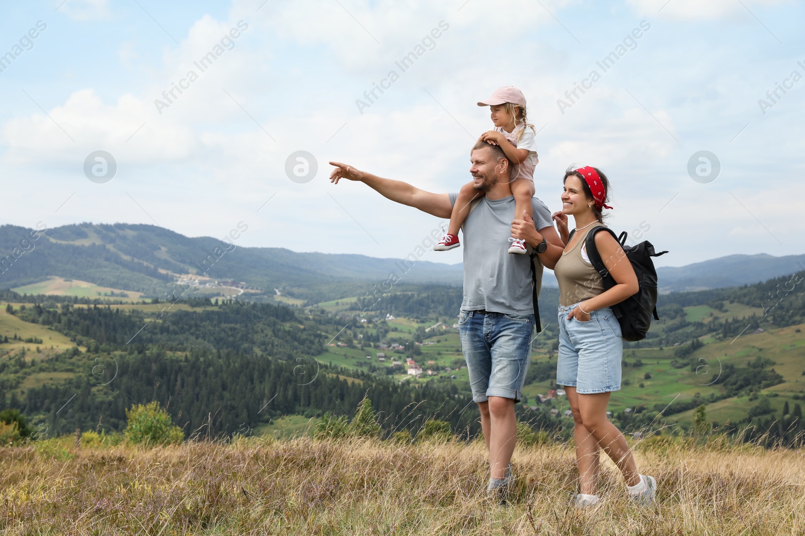 Photo of Happy family with backpacks travelling in mountains, space for text. Active tourism