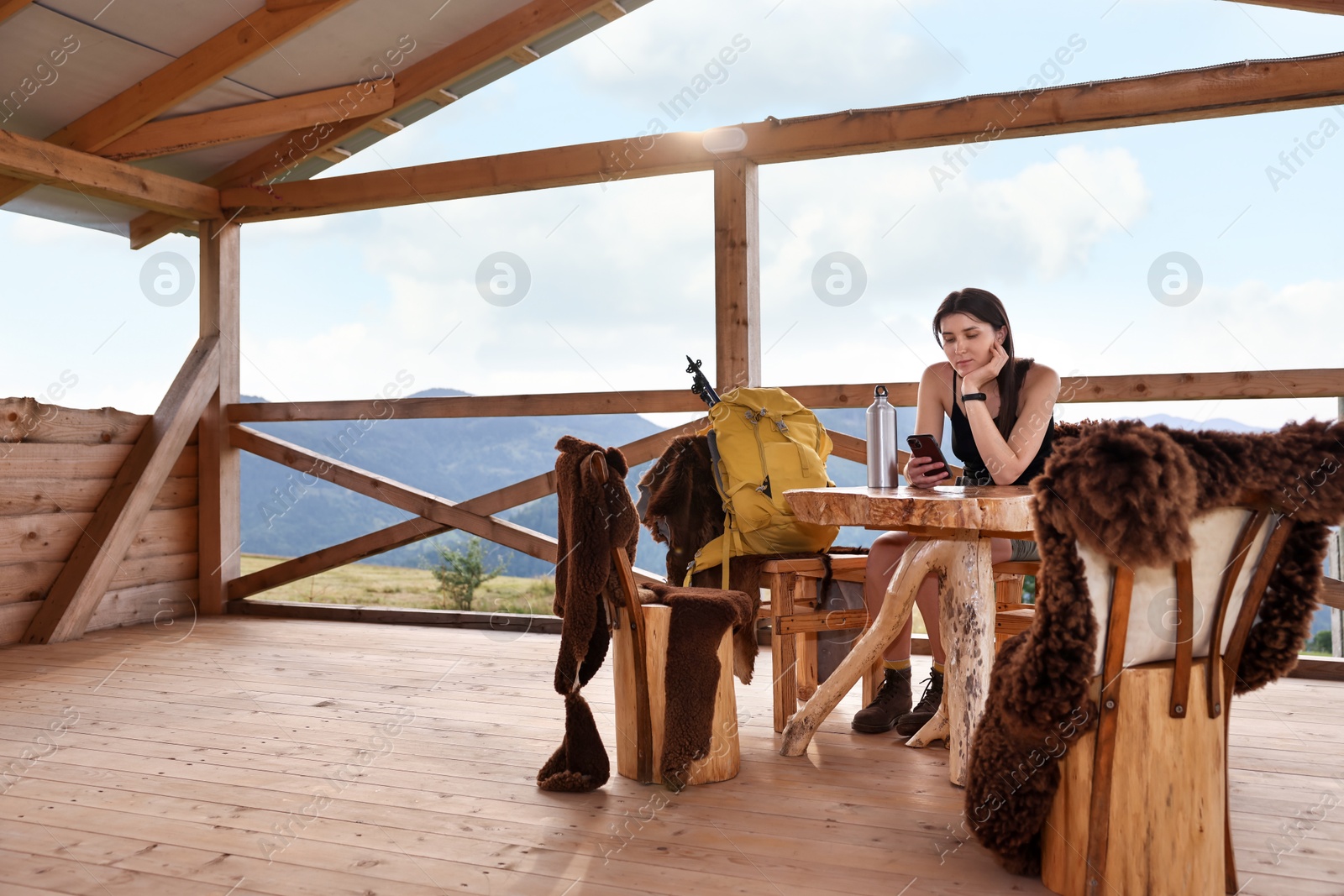 Photo of Young woman sitting at wooden table in cafe