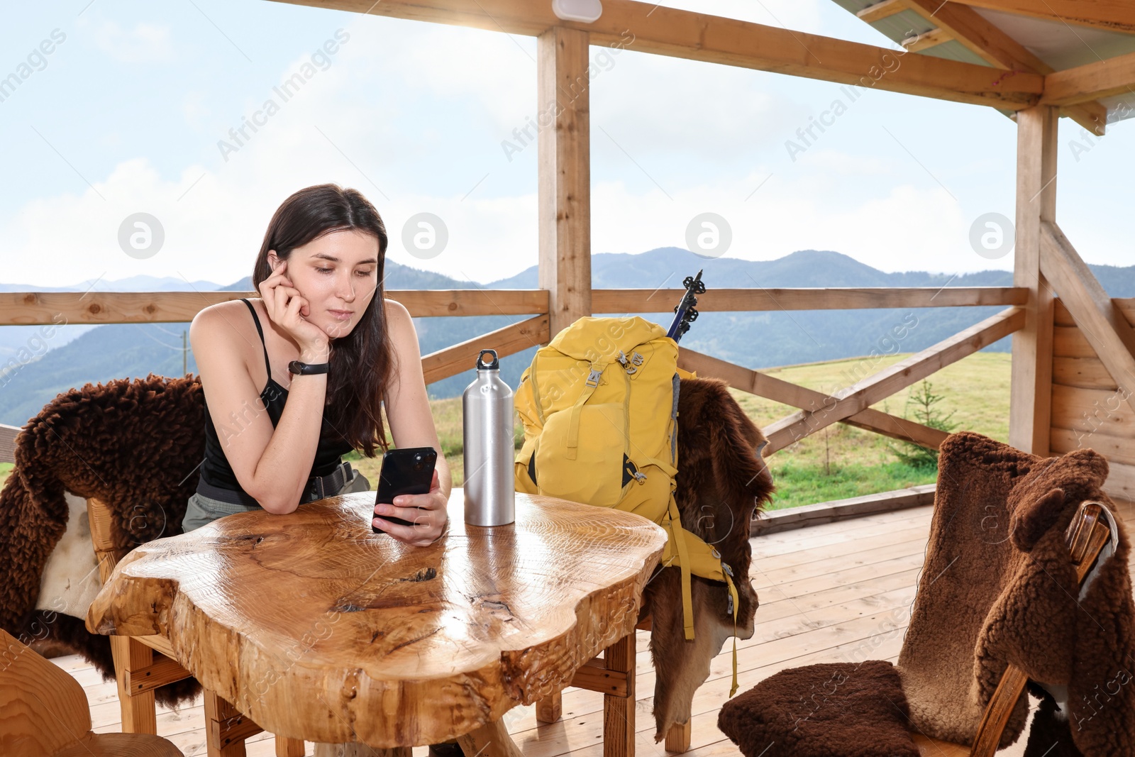 Photo of Young woman sitting at wooden table in cafe