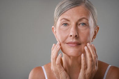 Photo of Face massage. Beautiful woman with healthy skin on grey background