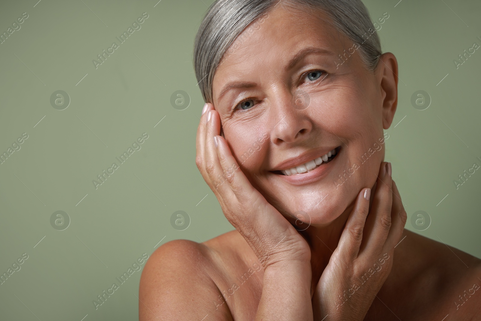 Photo of Face massage. Beautiful woman with healthy skin on light green background