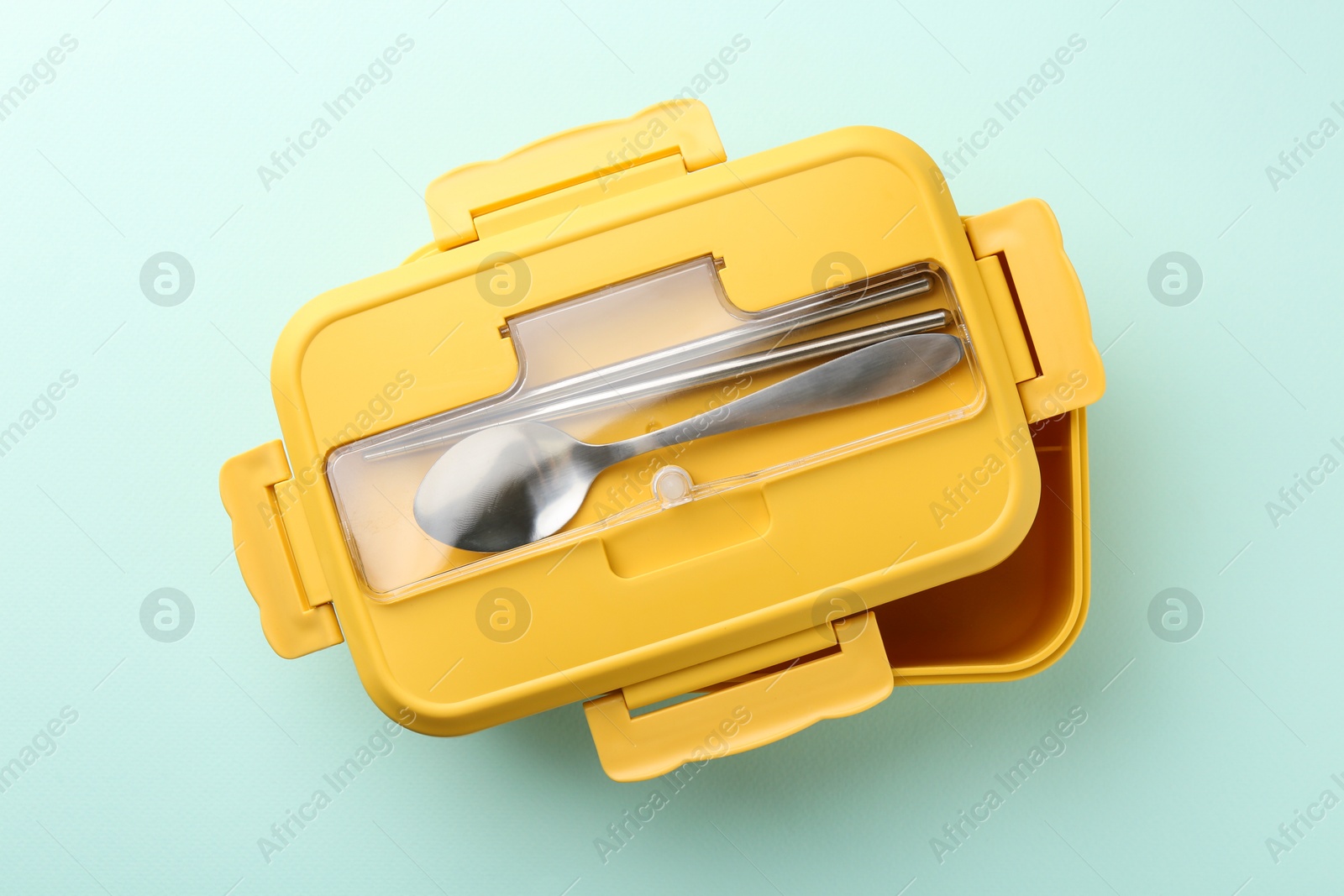 Photo of One lunch box with cutlery on light blue background, top view